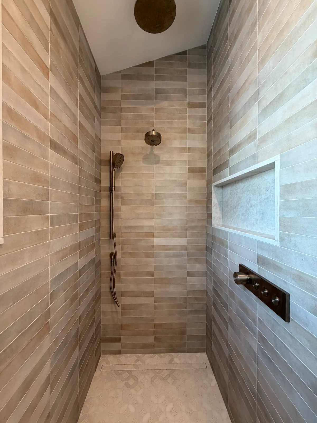 Walk-in shower with porcelain plank tile walls, natural stone niche accent, and brass fixtures — Brookline, MA bathroom by Davie Mac Tile