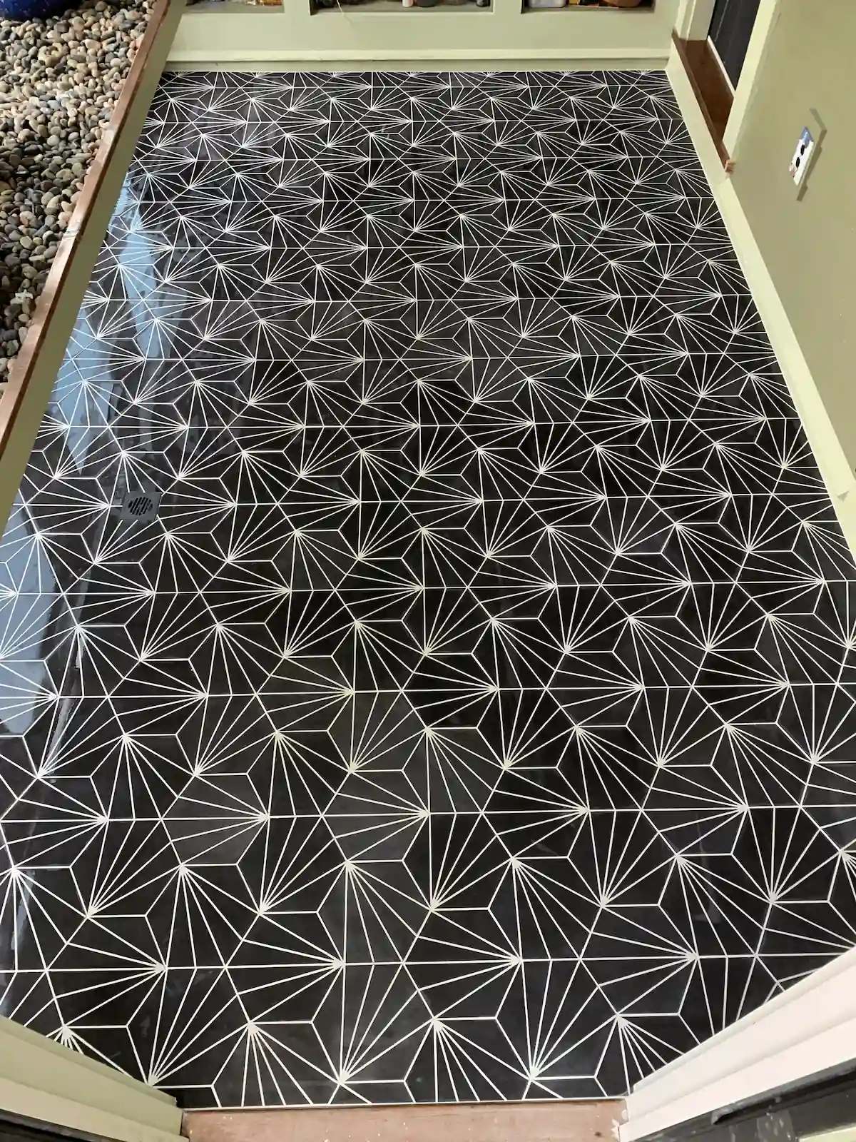 Custom cement tile floor installation with geometric starburst pattern by Davie Mac Tile