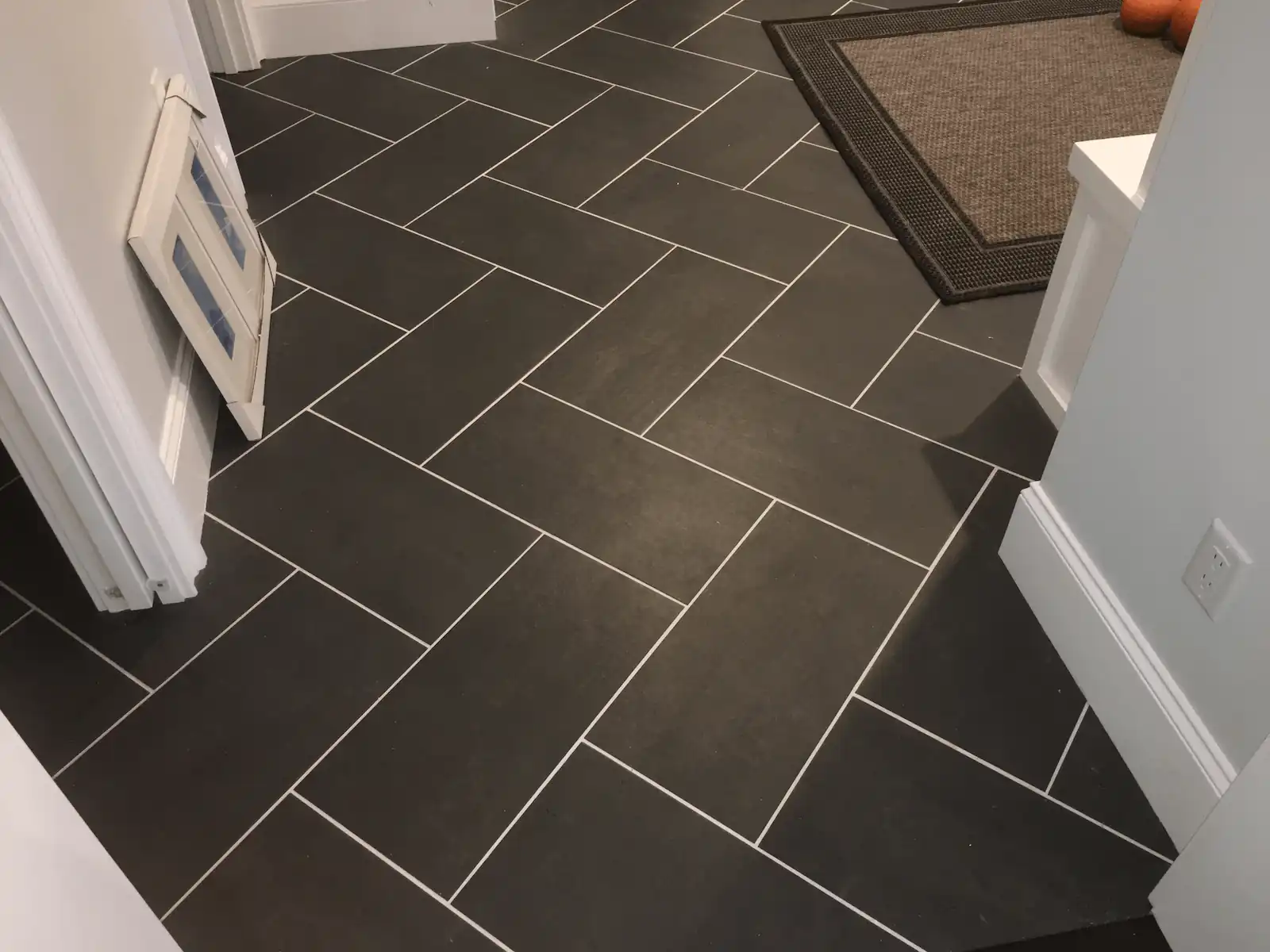 Herringbone pattern porcelain floor tile installation by Davie Mac Tile