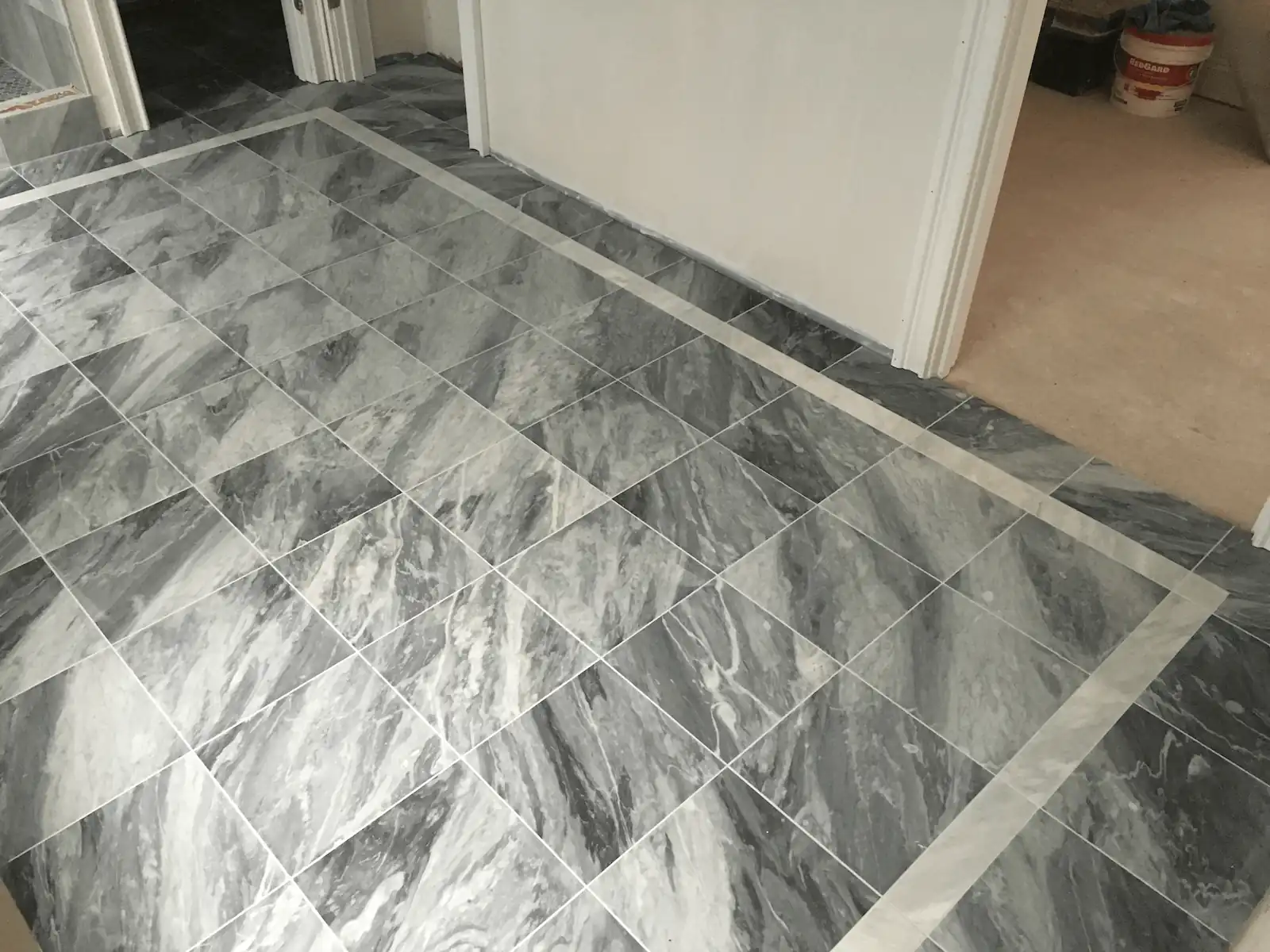 Marble floor tile installation with border detail by Davie Mac Tile
